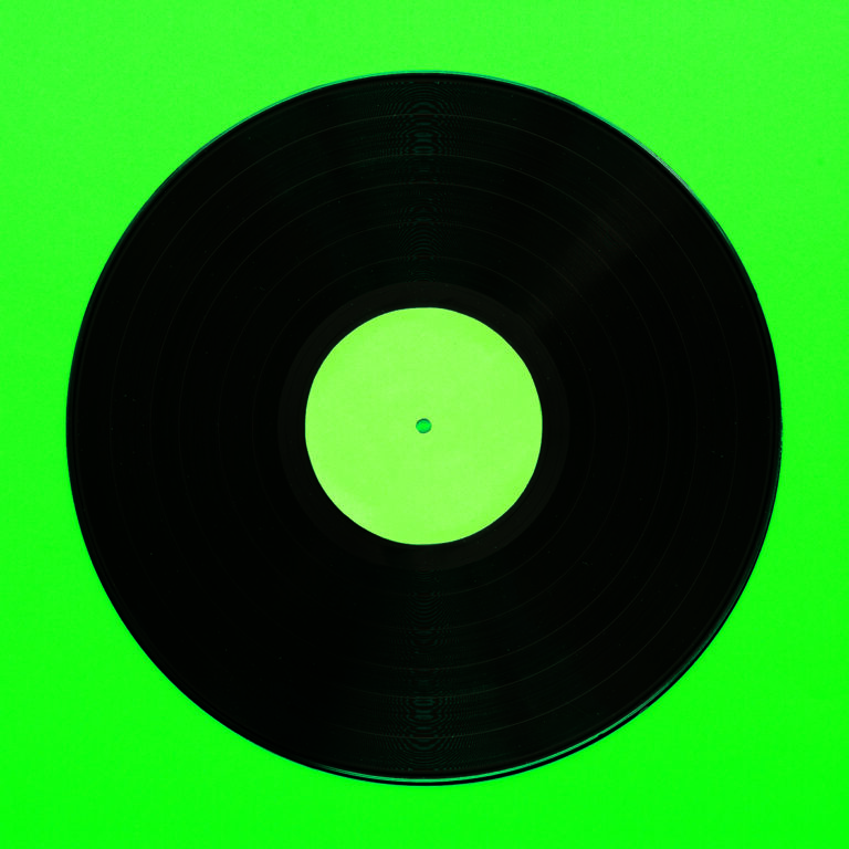 Minimalistische Schallplatte auf grünem Grund